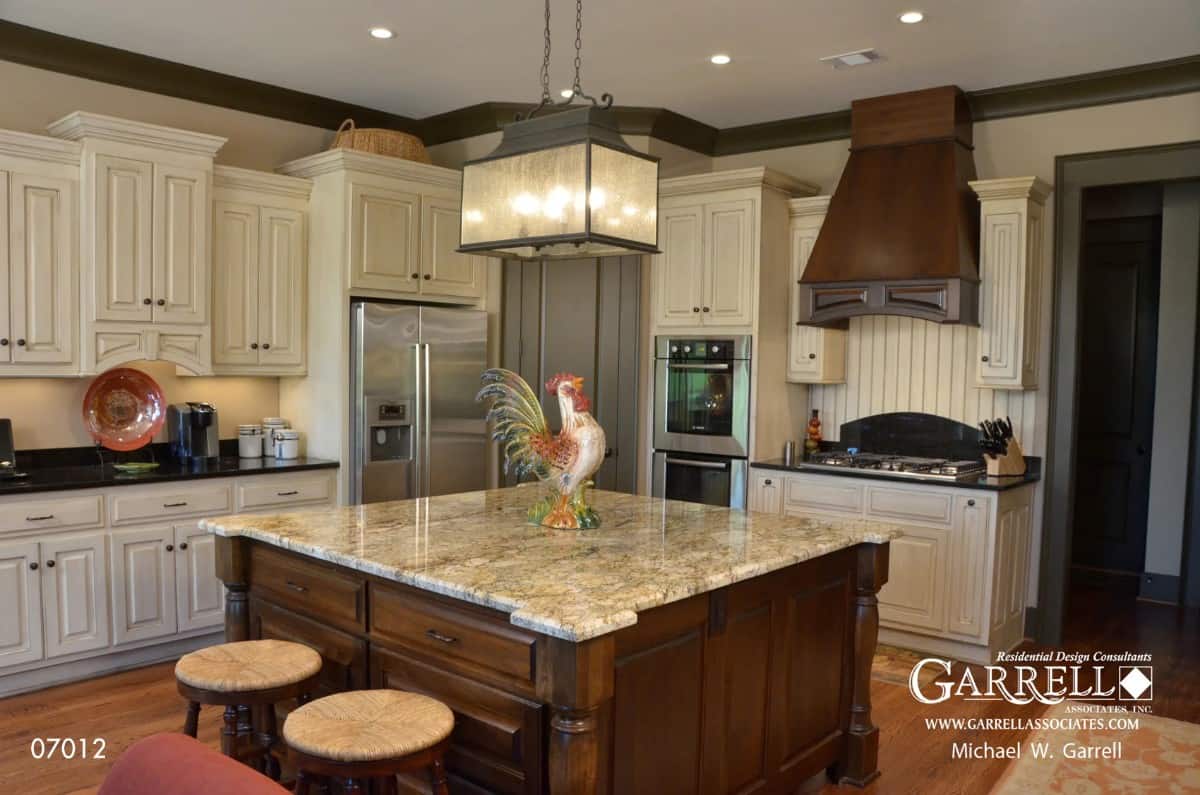 Kitchen with white cabinets, stainless steel appliances and a center island with seating for two.