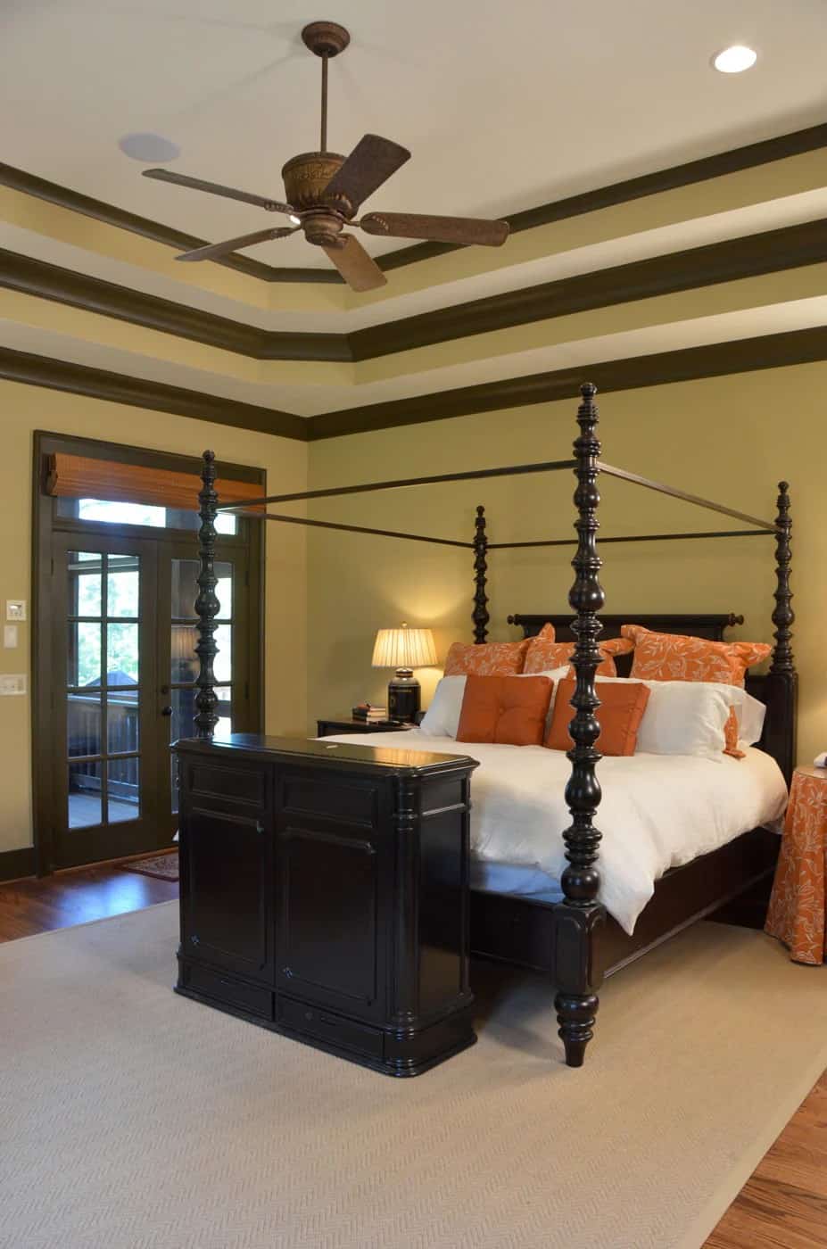 A stepped ceiling highlighted by wooden moldings crowns the primary bedroom.