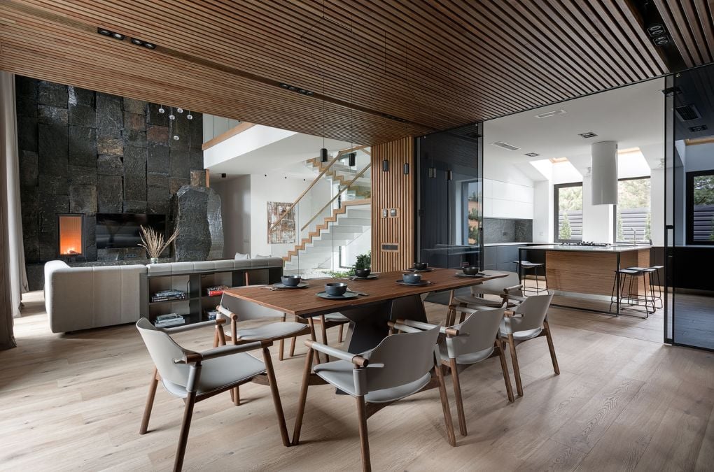 The dining room showcases a wooden table, wooden flooring, and a wooden ceiling.
