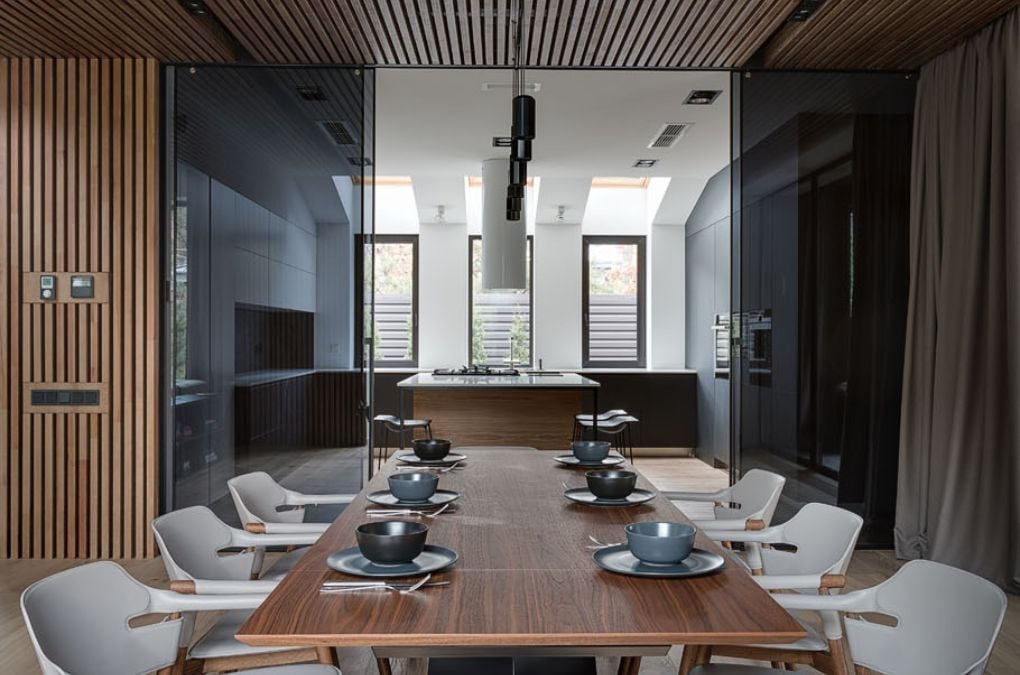 The dining room showcases a wooden table, wooden flooring, and a wooden ceiling.