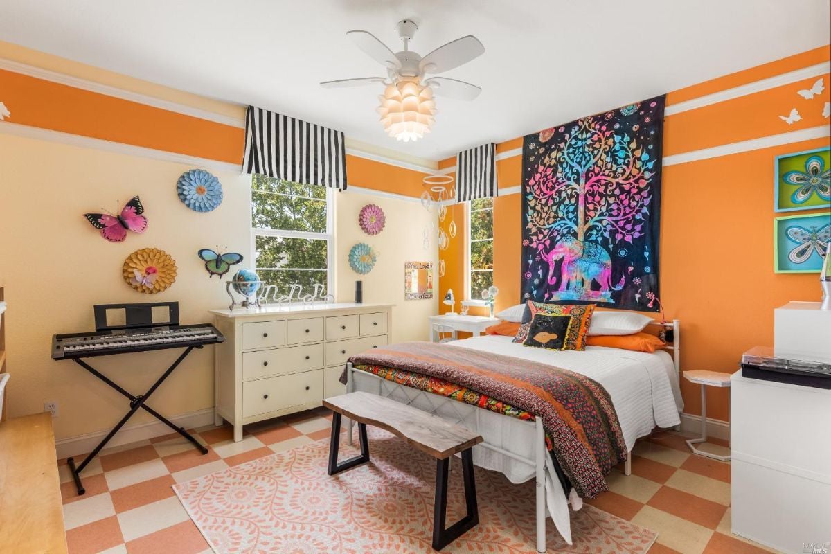 Bedroom with a ceiling fan, glass windows and drawers.
