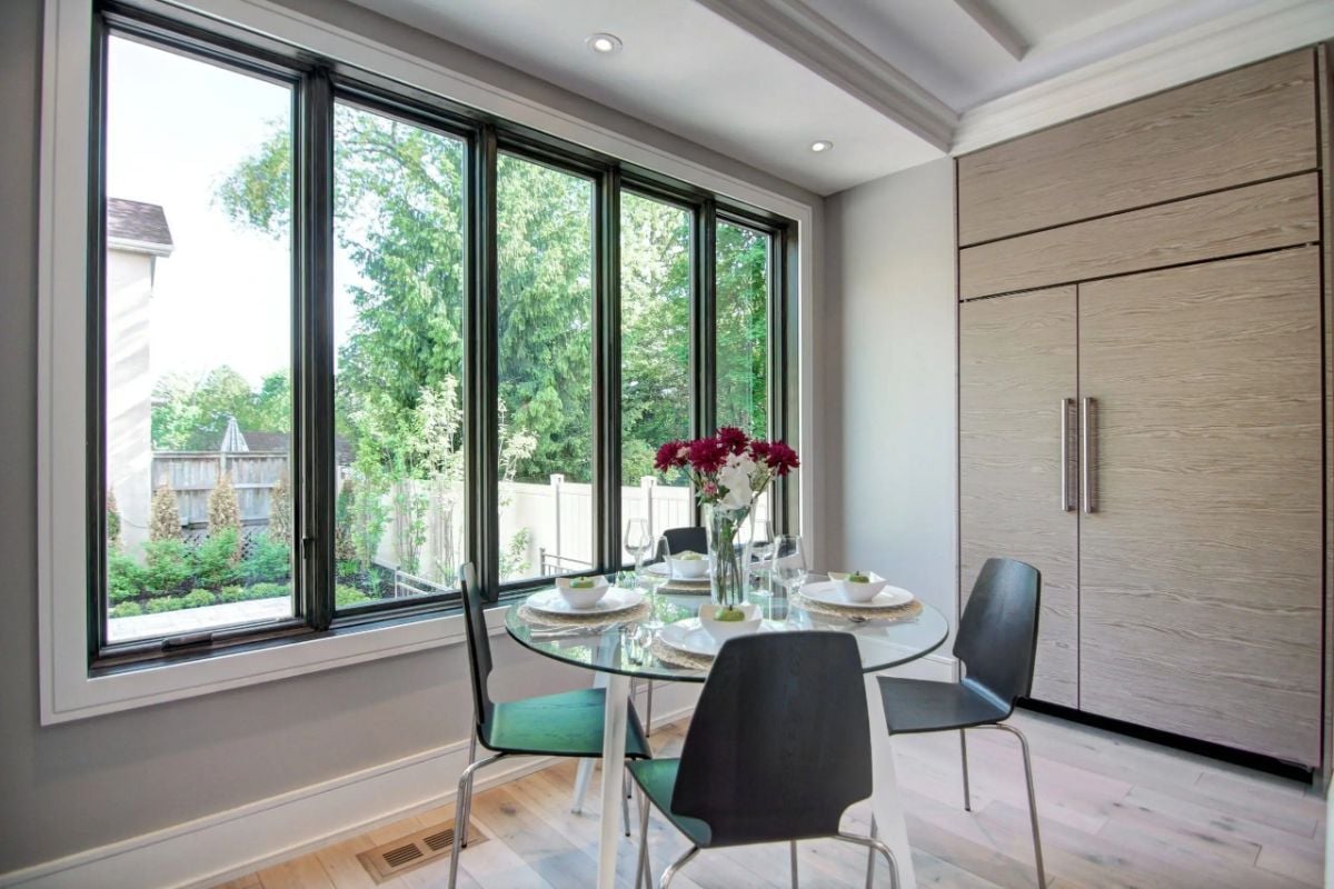 Breakfast area with a large glass windows, a glass table and chairs