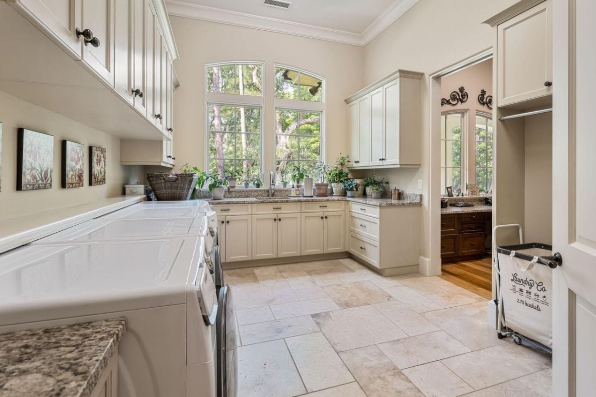 Laundry room with a sink, custom cabinetry and glass windows.