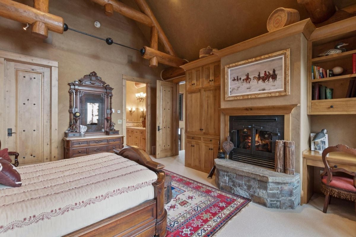 Bedroom with a fireplace and a large bed.