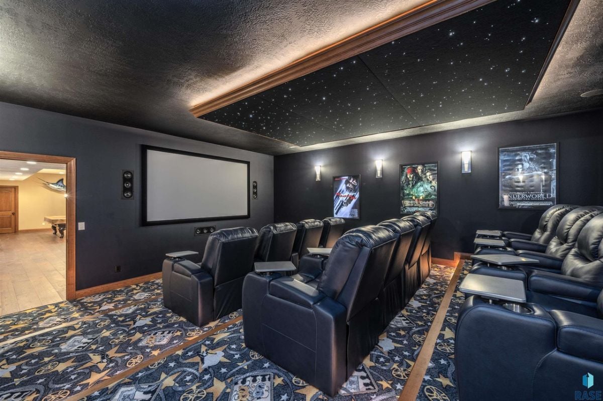 Home theater with couches and a large screen.