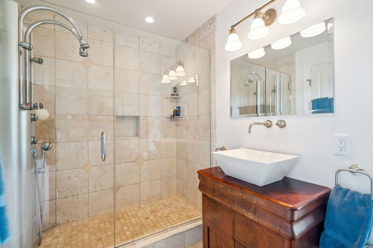 Bathroom with a sink, custom lighting and a shower.