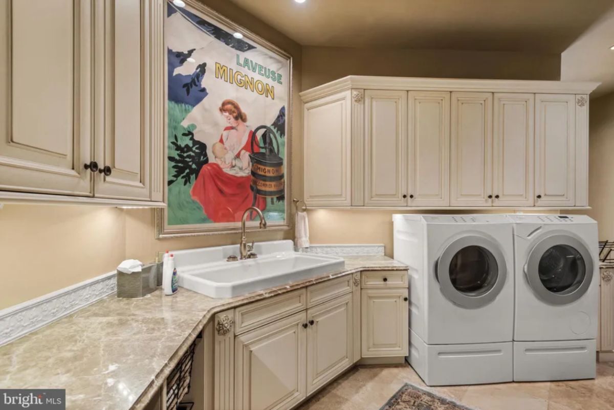Laundry room with a sink and custom cabinetry.