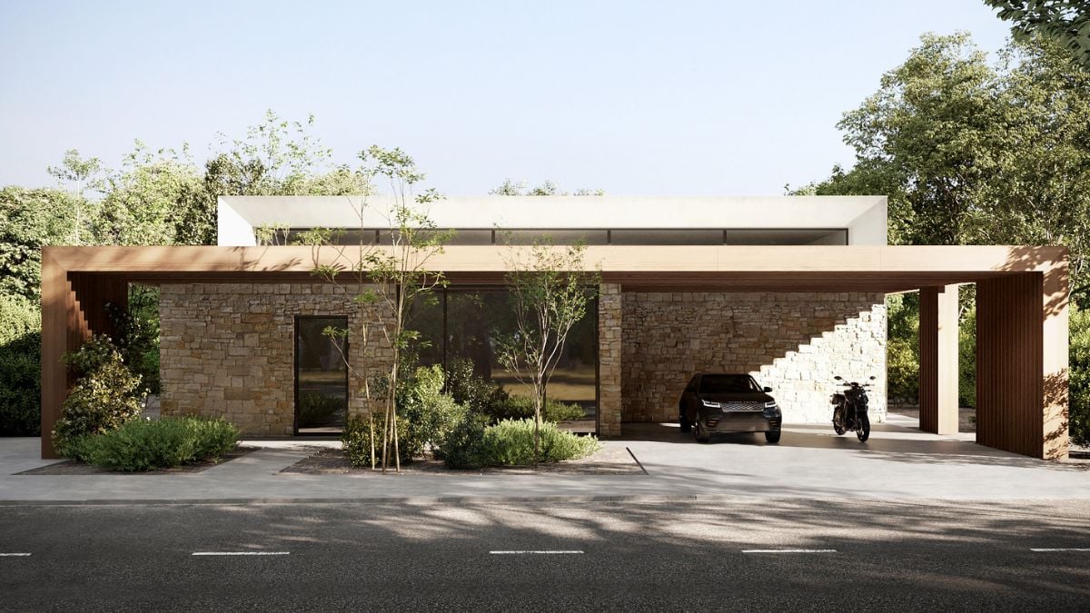An asphalt drive way and a covered garage with bricks wall