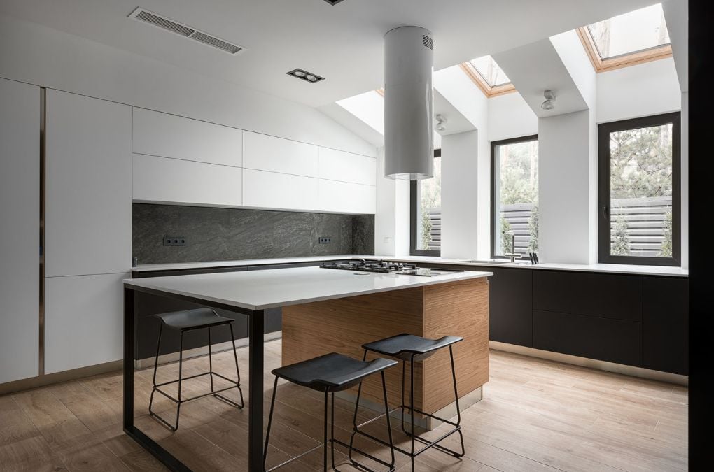 A kitchen with center island and glass windows