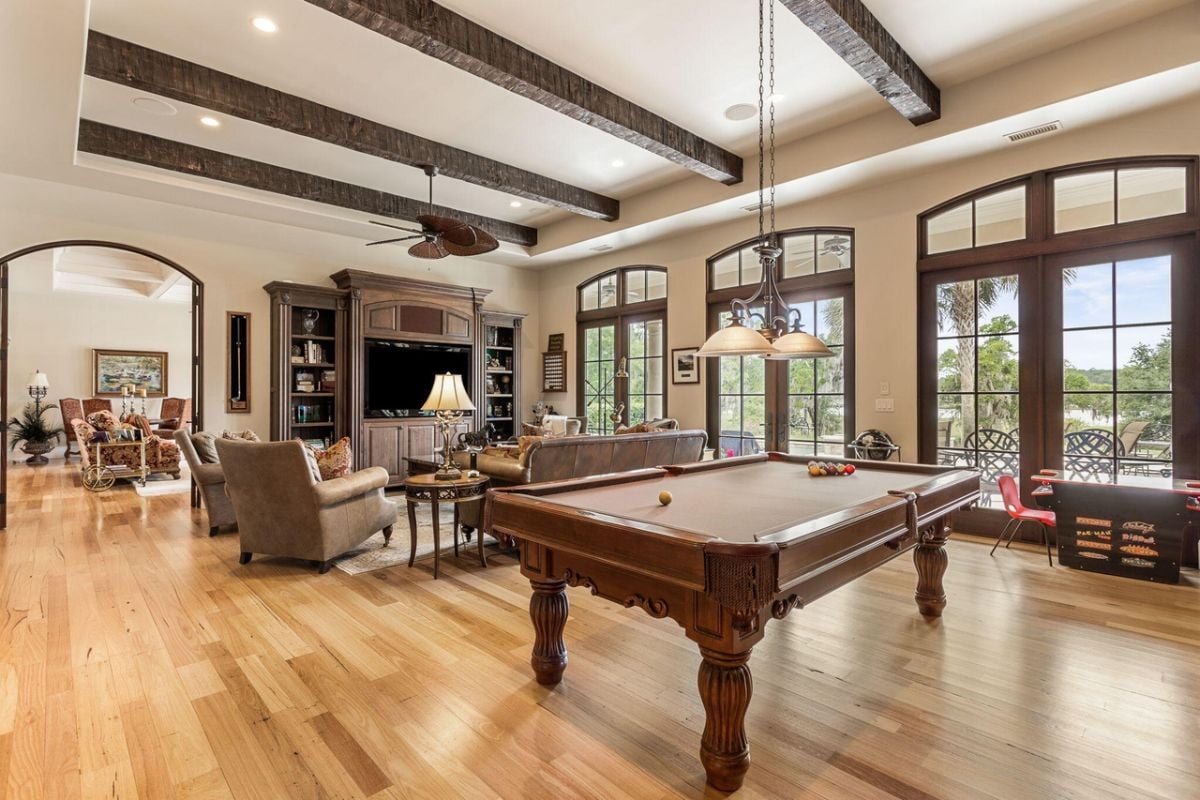 Billiards room with couches and a fireplace.