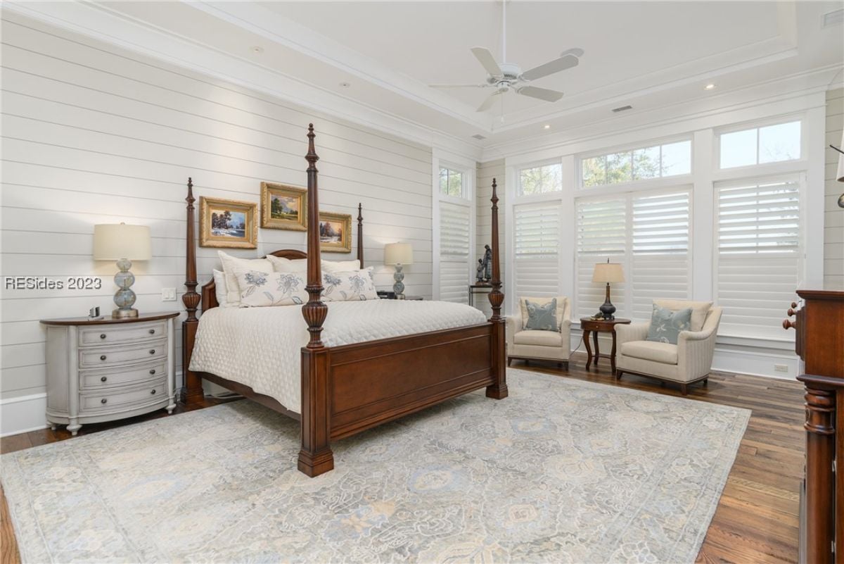 Bedroom with a large bed, custom lighting, and a ceiling fan.