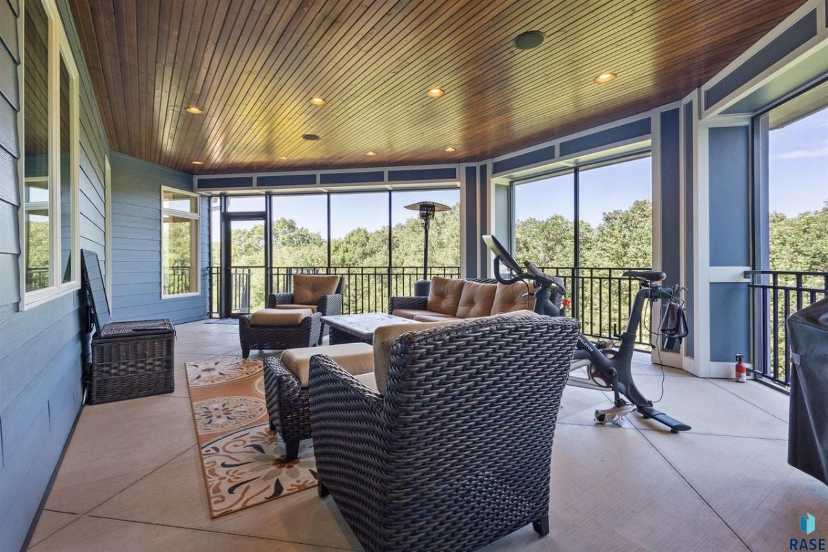 Balcony with couches, custom lighting and a view of the trees.