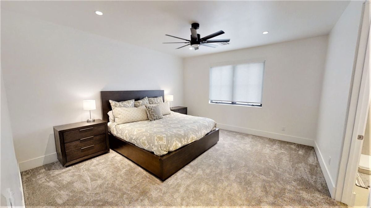 Bedroom with carpet flooring, custom lighting and a ceiling fan.