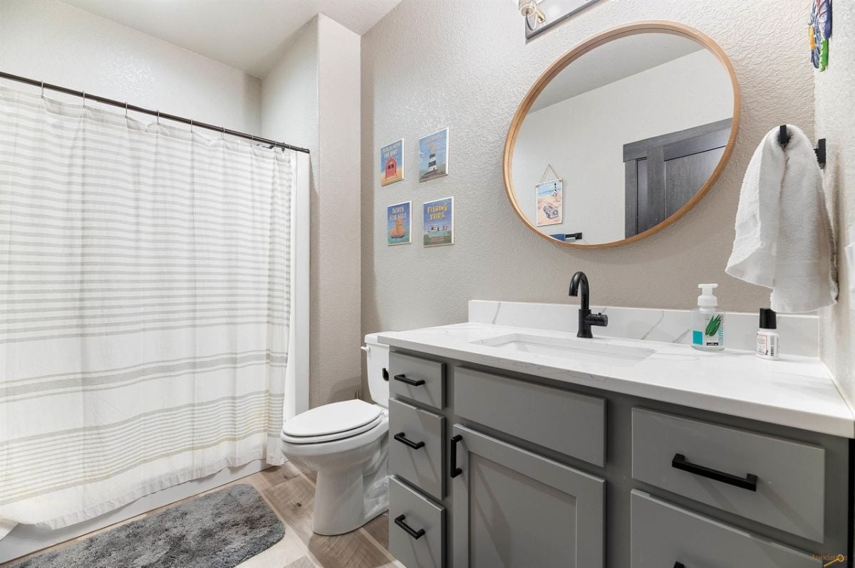 Bathroom with a sink, drawers, and a toilet.