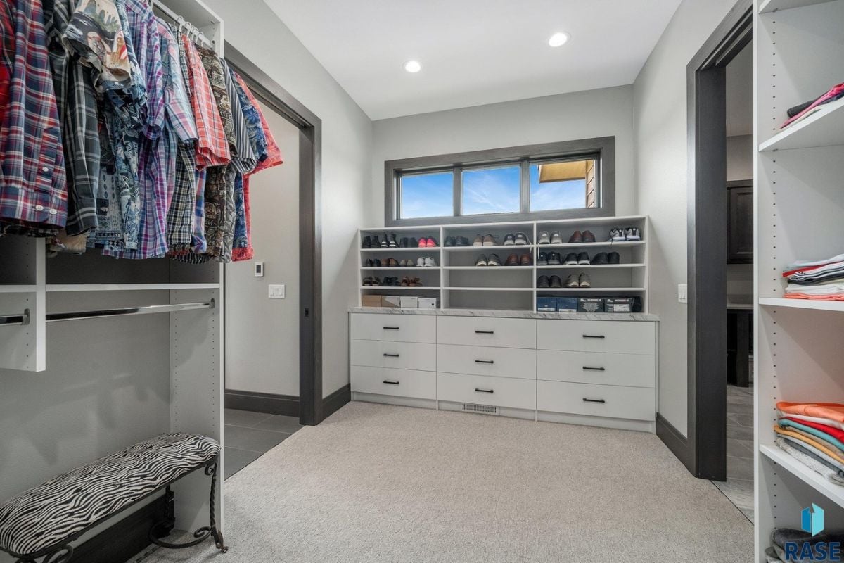 Walk-in closet with carpet flooring, shelves and drawers.