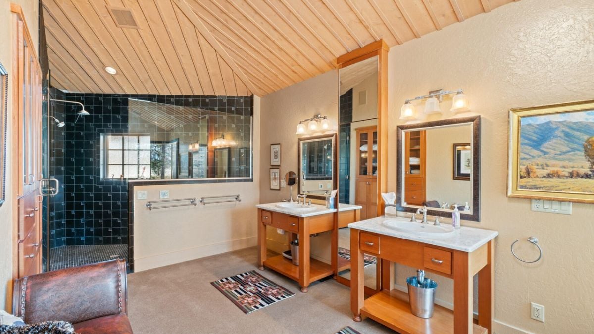 Bathroom with sinks, shower and custom lighting.