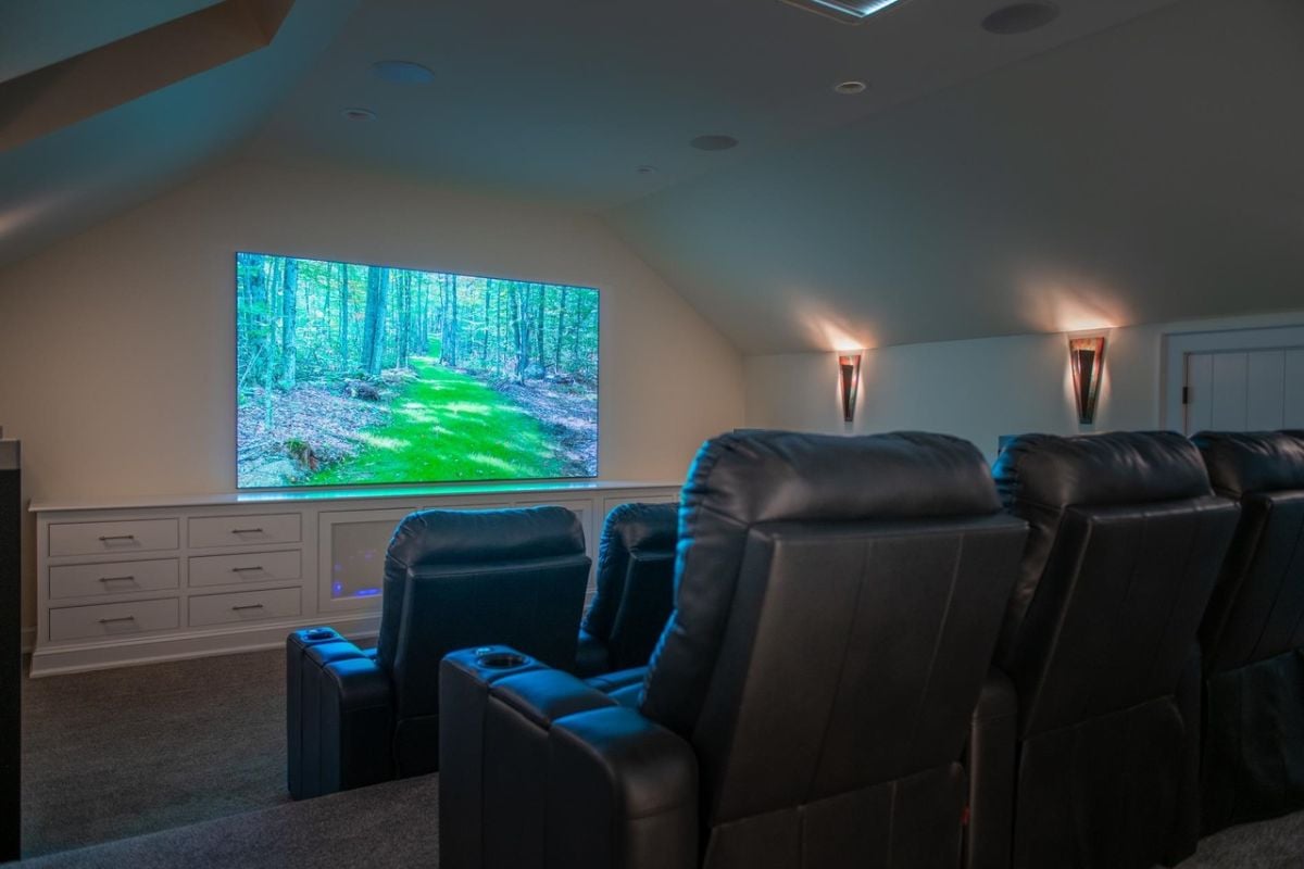 Home theater with reclining leather seating and a large screen.