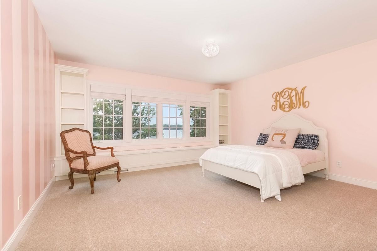 Bedroom with pink walls and a white bed.