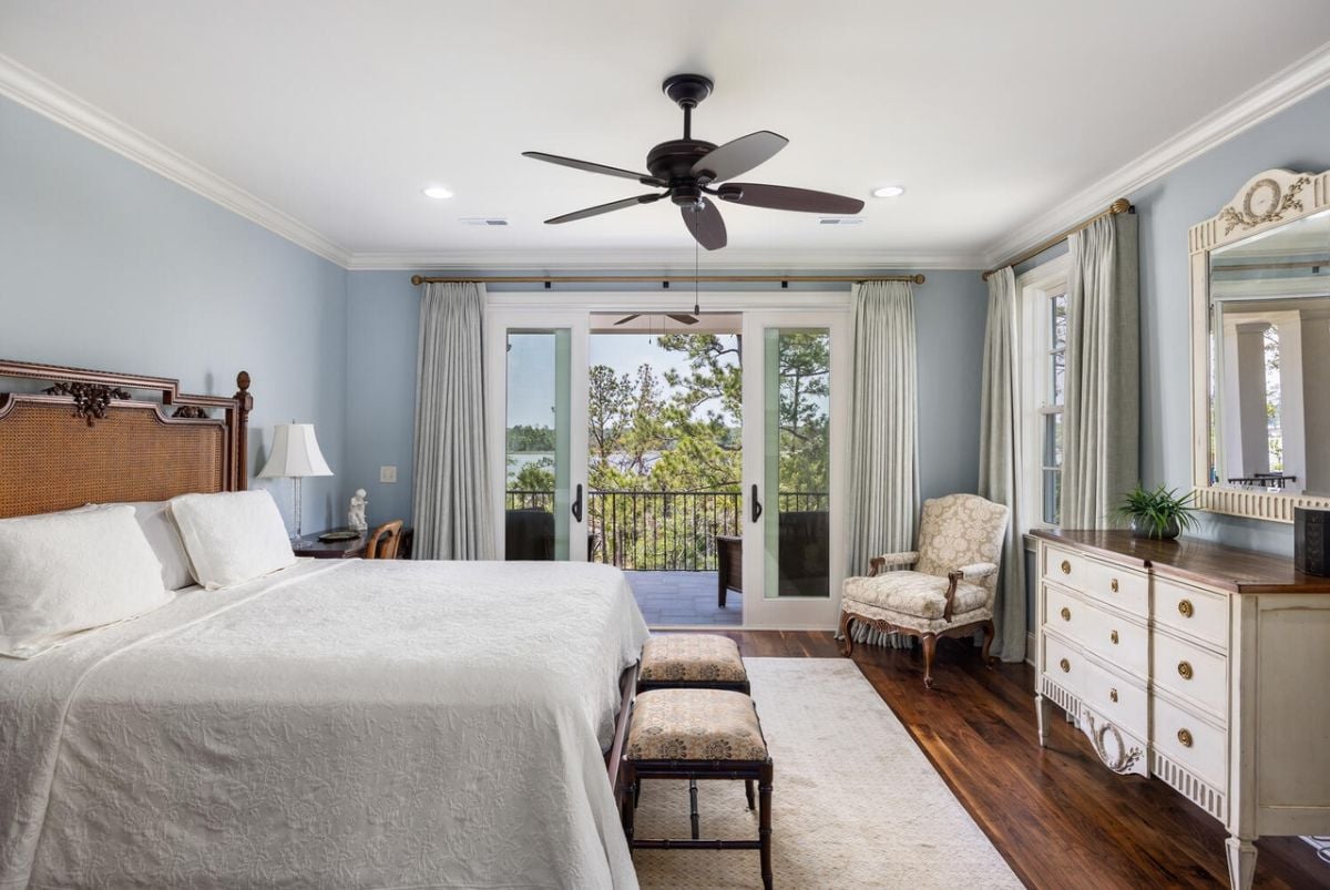 Bedroom with wood flooring and a private balcony.