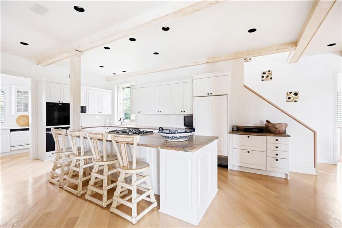 Kitchen features with island table and chairs.