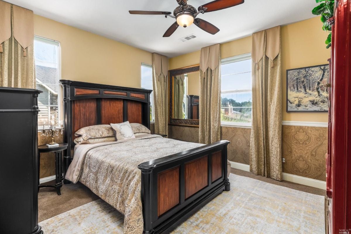 Bedroom with glass windows, a large bed, and a ceiling fan