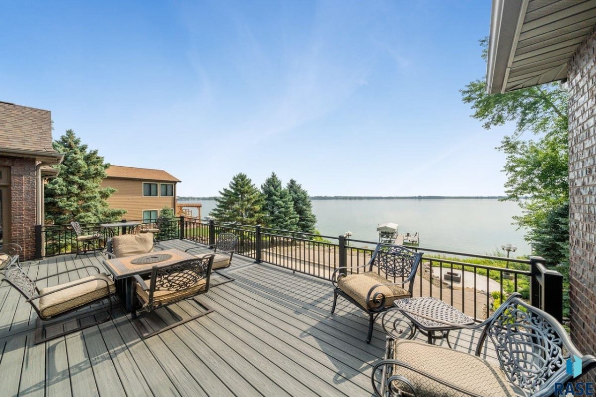 Patio with tables, chairs, and a view of the lake.