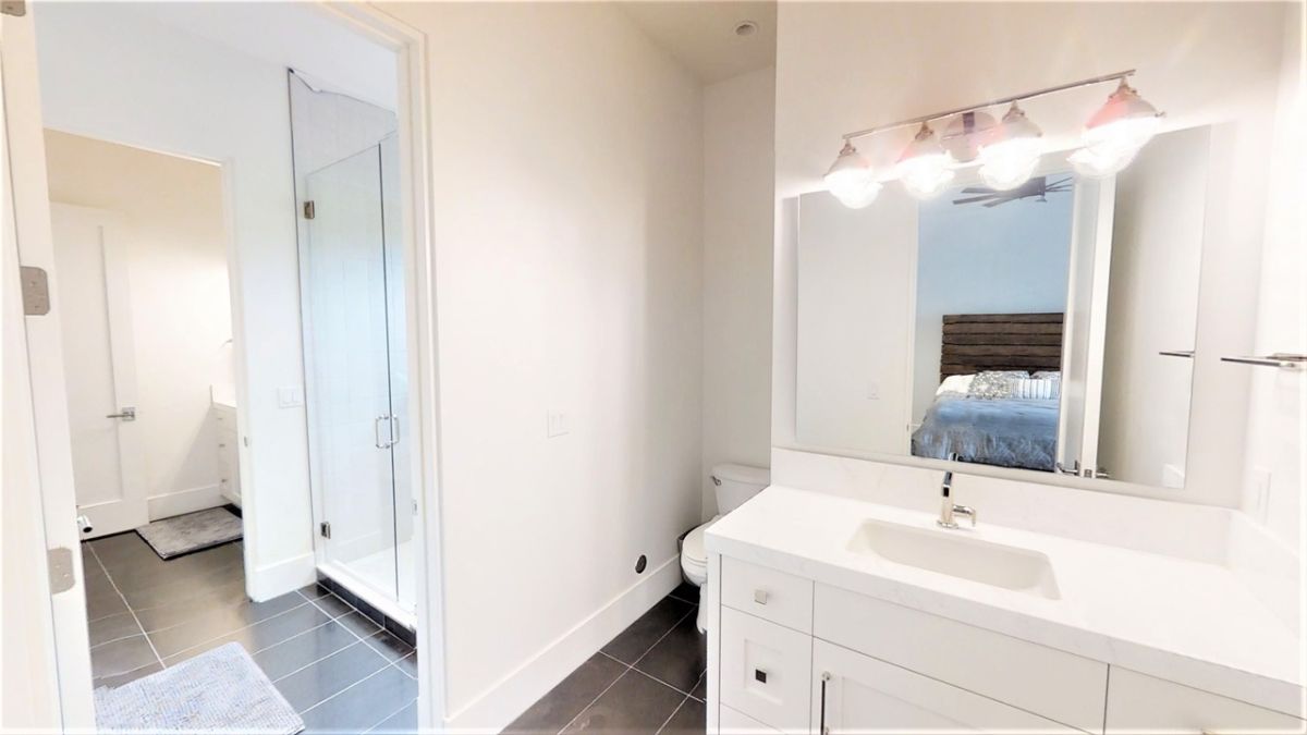 Bathroom with a sink, shower, and toilet.