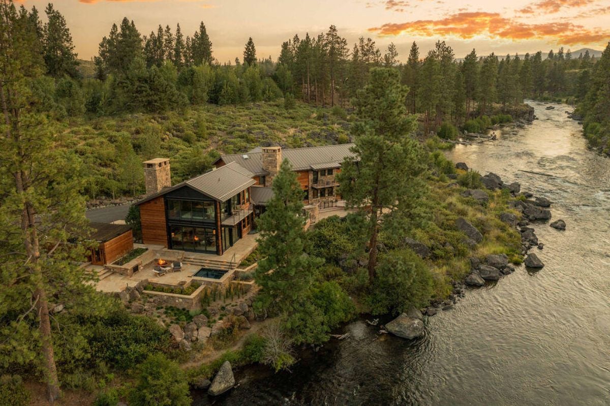 Aerial view of the mansion with trees and river.