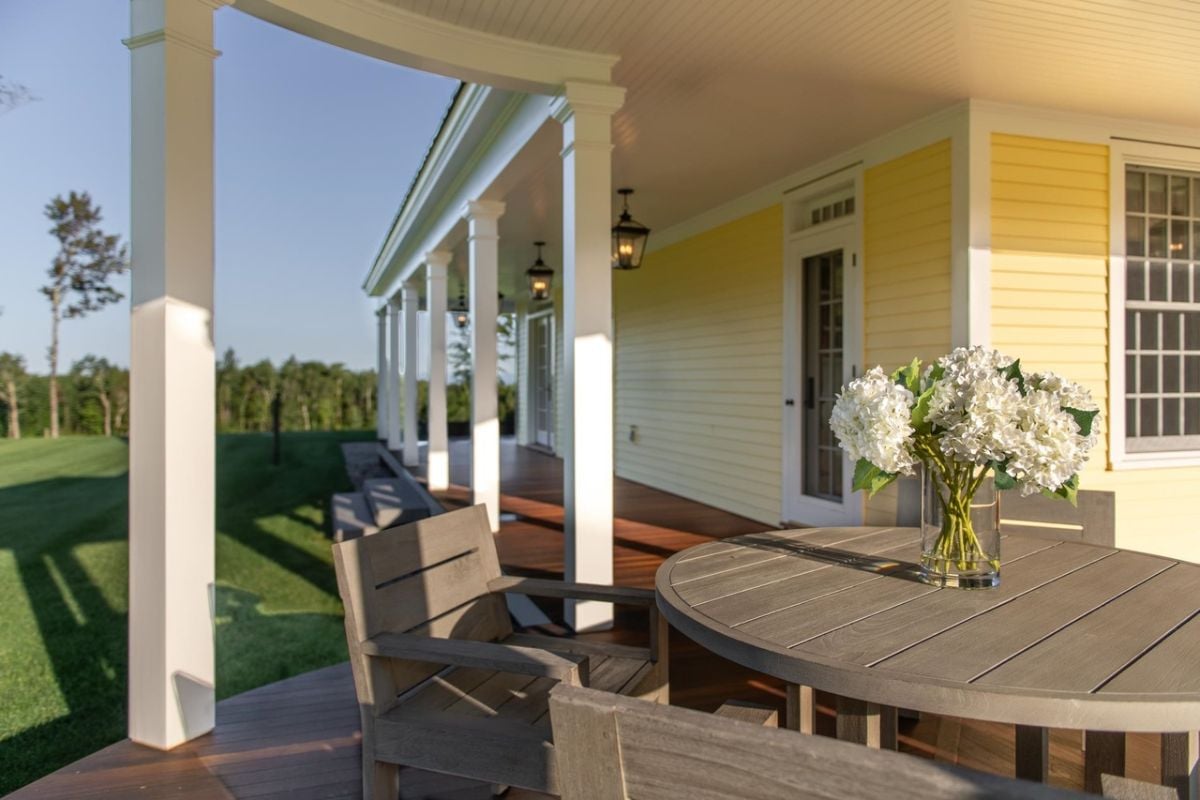 Porch with wooden table and chairs.