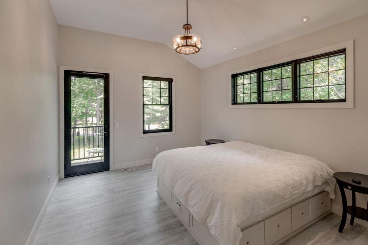 Bedroom with glass doors, glass windows, and custom lighting.