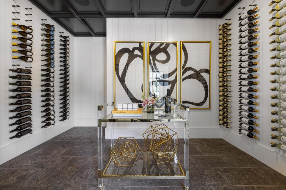 Wine room is showcased through a glass wall and pivot door.