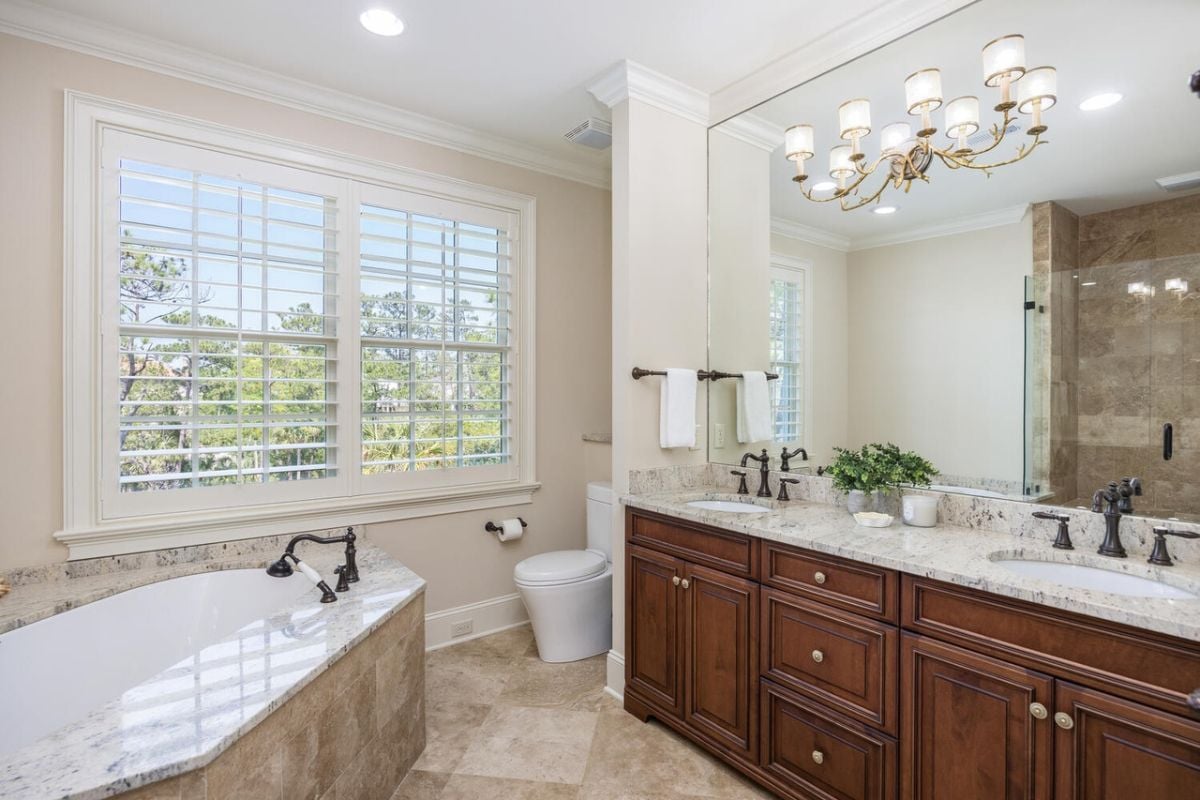 Bathroom with sinks, a bath tub and a toilet.