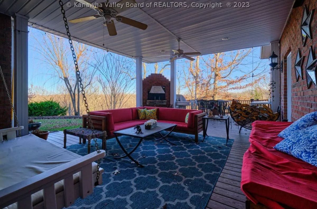 Porch with a couch, ceiling fans, and a table.