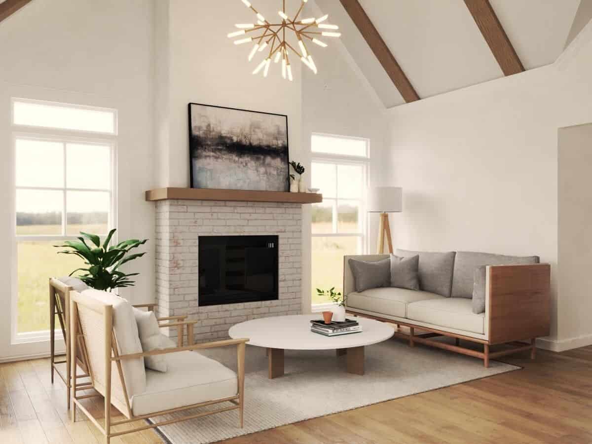 Family room with a brick fireplace, cushioned seats, and a low coffee table under a cathedral ceiling with exposed beams.