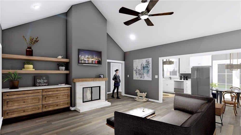 Great room with a dark sofa, wooden built-ins, and a fireplace topped with a TV.