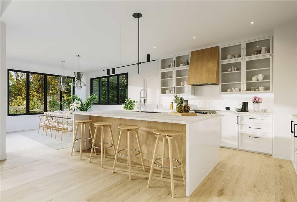 Kitchen and dining area with light hardwood flooring and sliding windows overlooking the lush backyard.