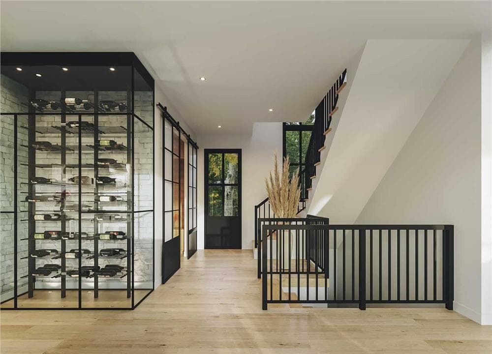 Foyer with a glazed entry door and a staircase framed with wrought iron railings.