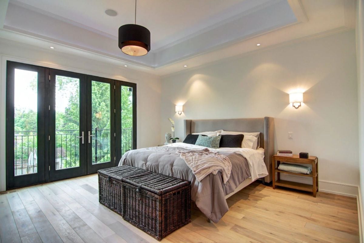 Bedroom with custom lighting, a large bed, and a large glass doors.