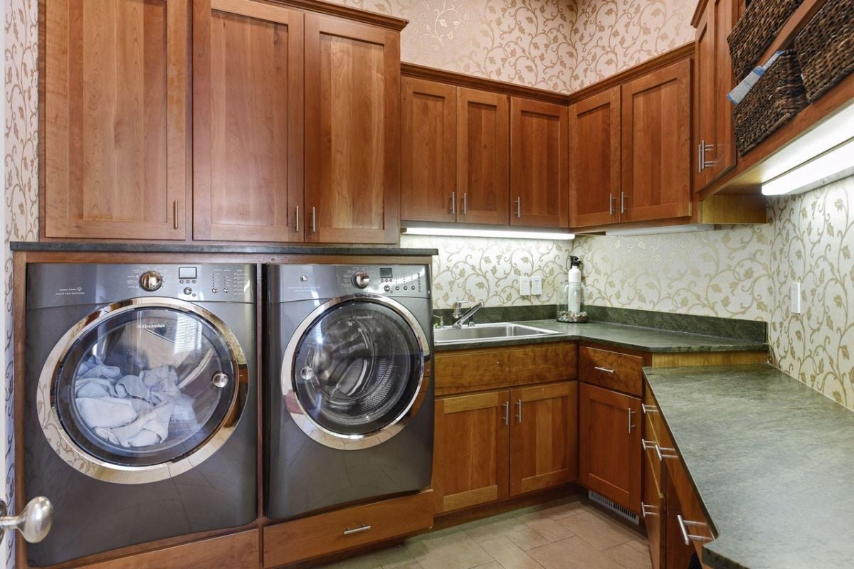 Laundry room with a sink and custom cabinetry.