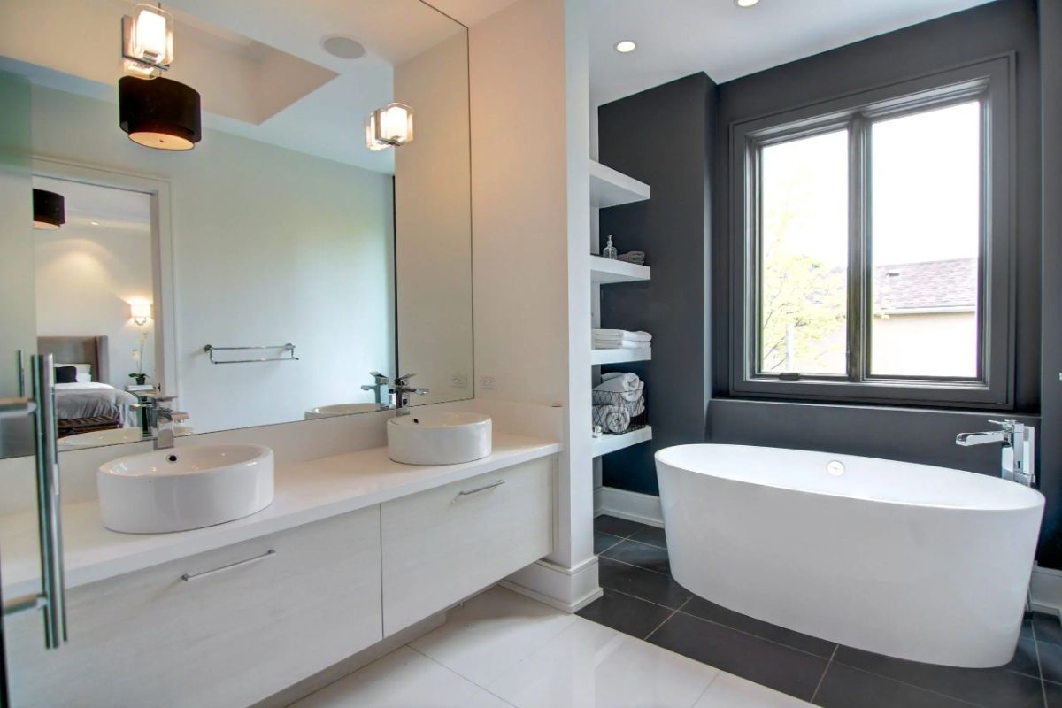 Bathroom with a large soaking tub, large mirror and sinks