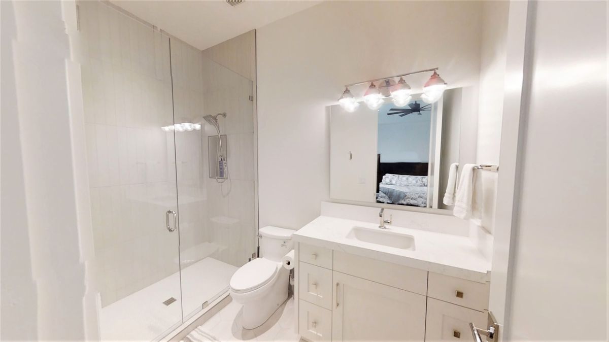 Bathroom with a sink, shower, custom lighting and toilet.
