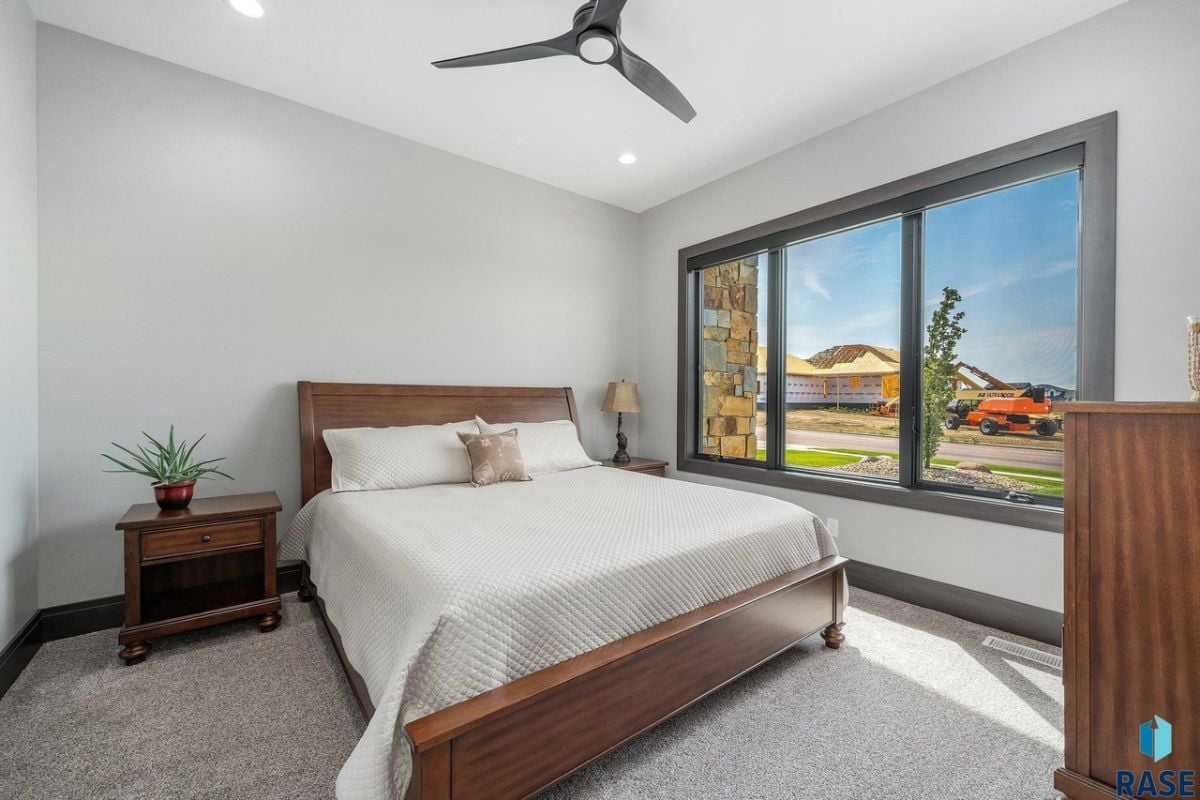 Bedroom with carpet flooring, custom lighting and glass windows.
