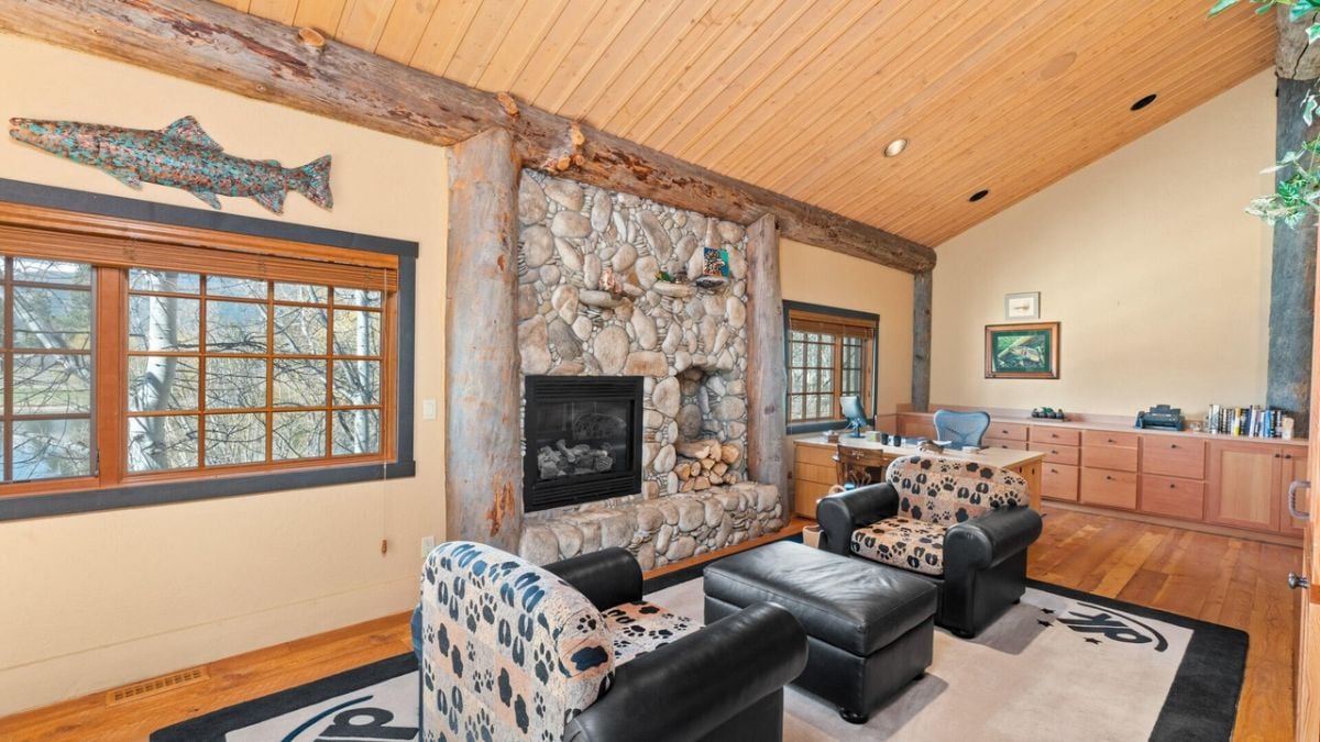 Home office with couches, fireplace and wooden drawers.