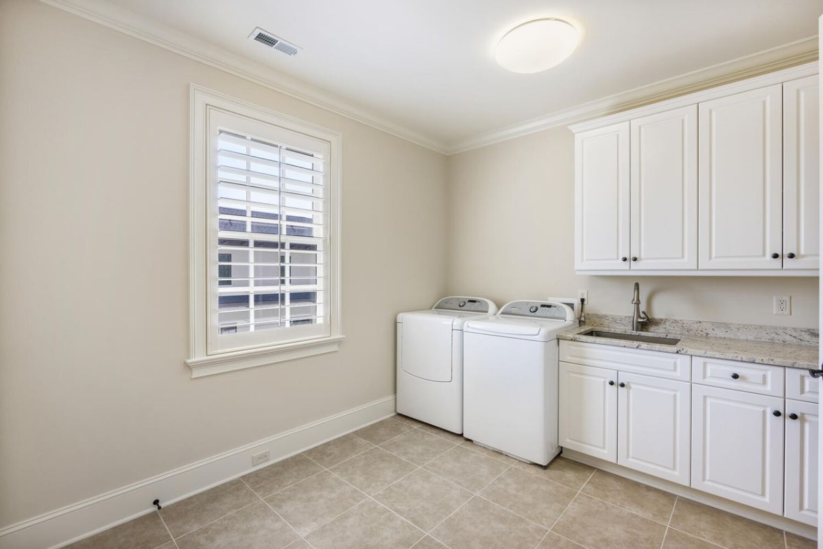 Laundry room with sink and storage closets.
