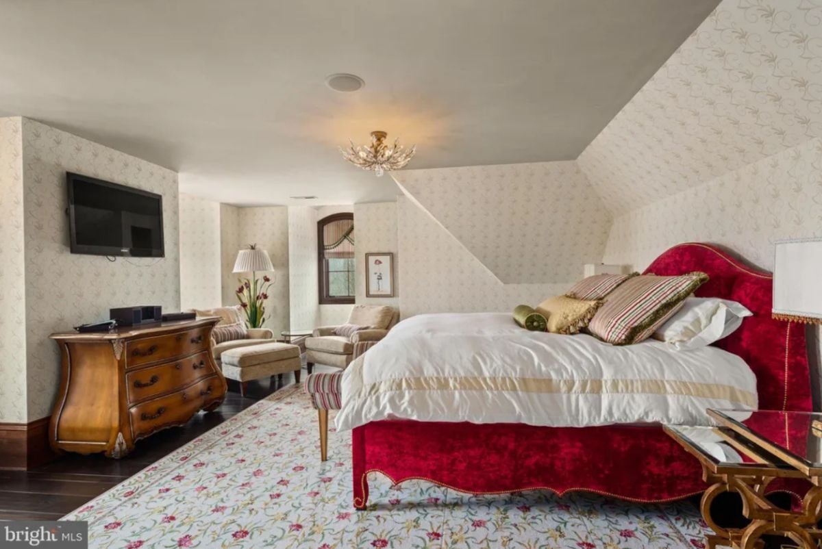 Bedroom with a TV, wood flooring and a large rug.