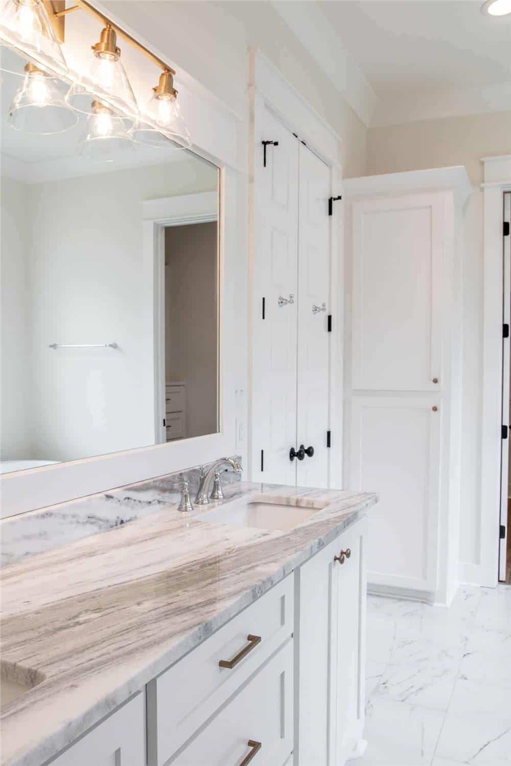 Primary vanity with double sinks, a marble countertop, and a large rectangular mirror.