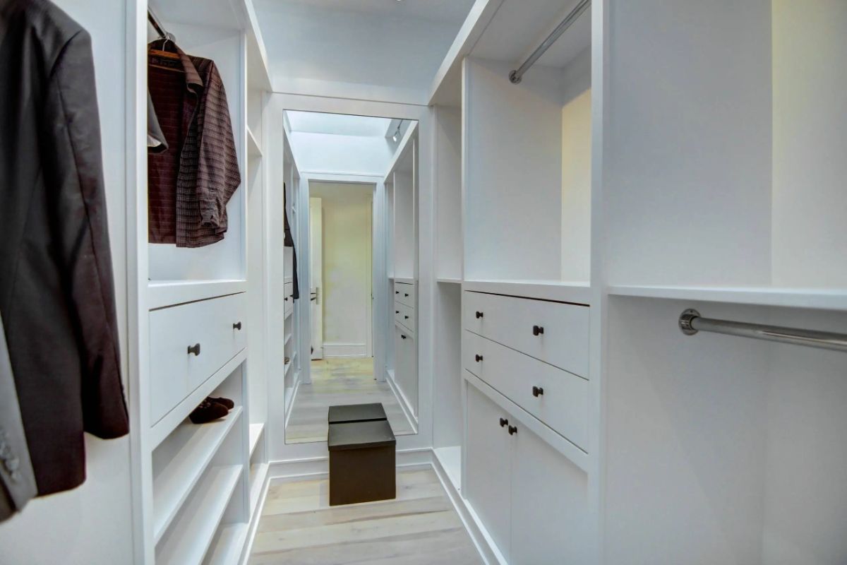 Walk-in closet closet with white shelves and cabinets.