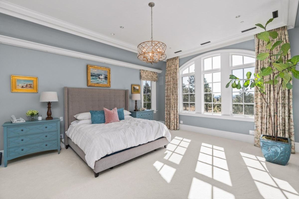 Bedroom with carpet flooring, glass windows, and a large bed.