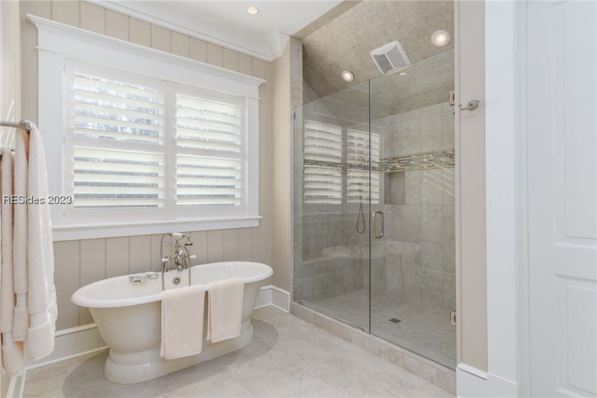 Bathroom with tile flooring, a bath tub and a shower.
