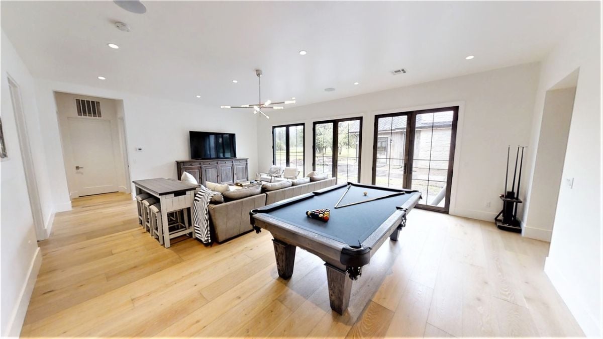 Billiards room with couches and a TV.